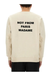 Cream-colored drôle de monsieur men’s sweatshirt with bold black not from paris madame text on the back