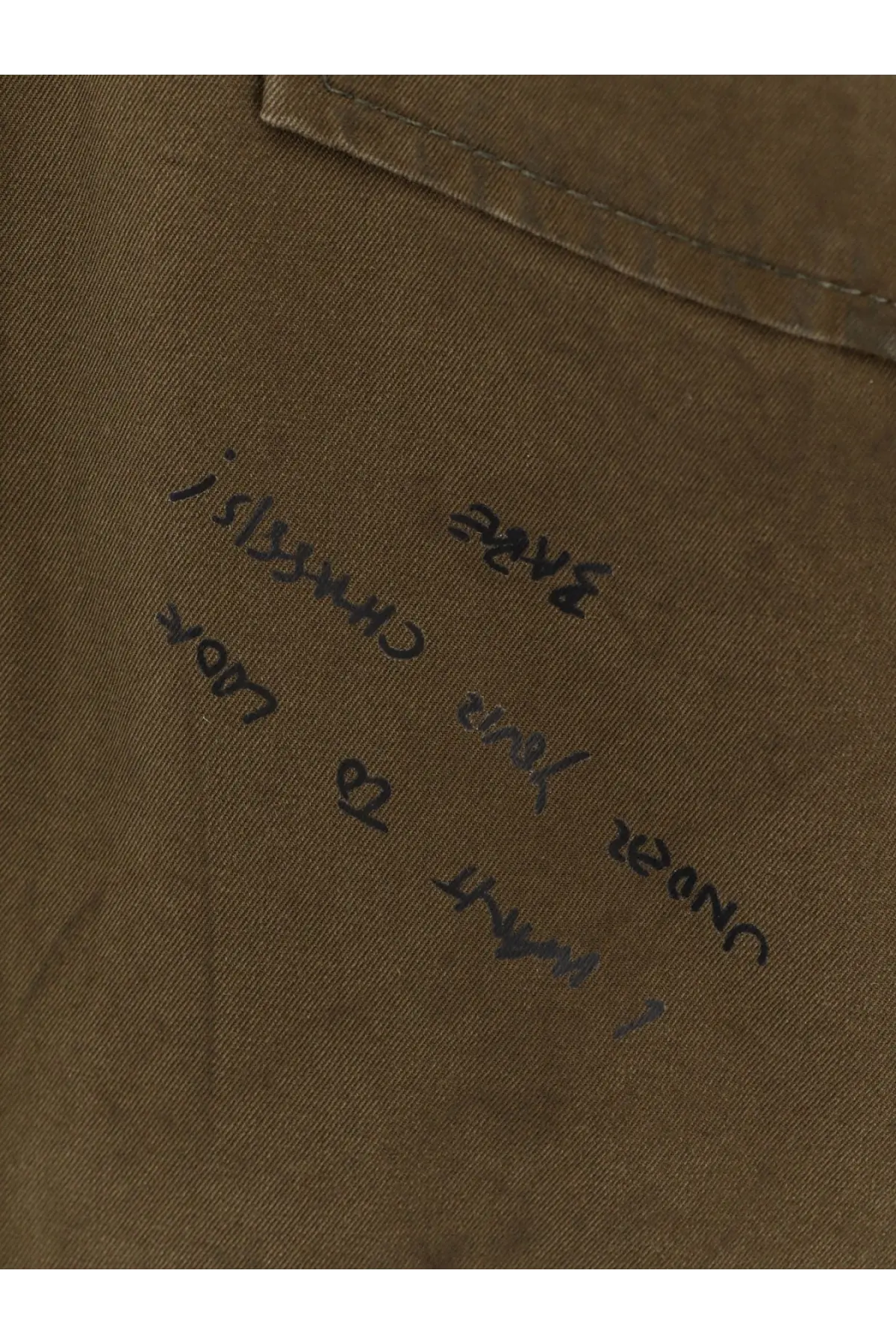 A close-up of a khaki cotton fabric pocket with handwritten text on the Dsquared2 men’s bros padded jacket beige