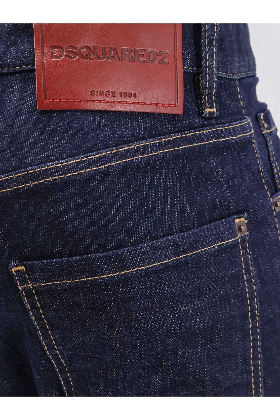 Dark blue denim jeans with a brown leather dsquared2 patch since 1984 on the back for men cool guy style