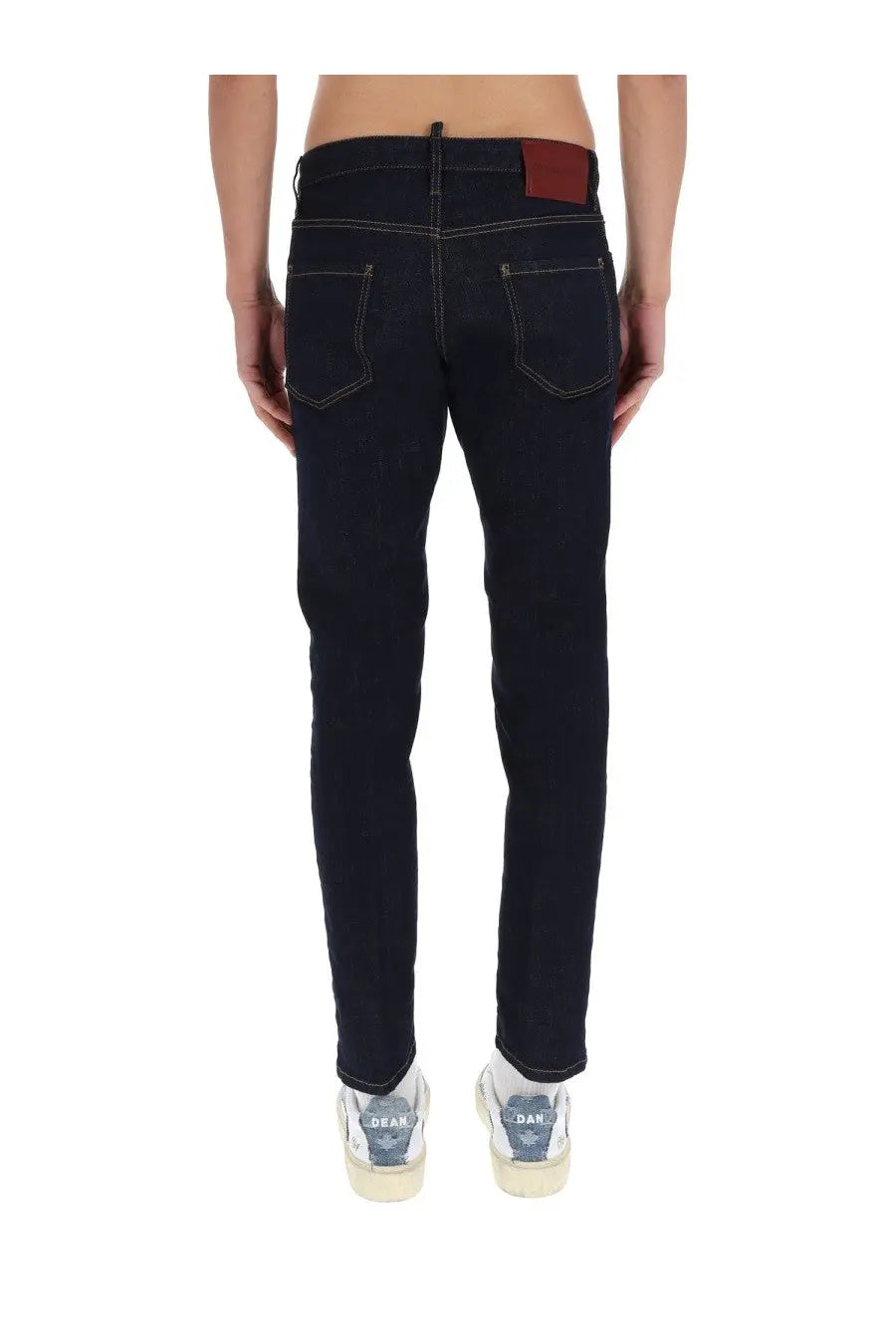 Dsquared2 men’s slim fit dark wash denim jeans with contrasting stitching and brown leather brand patch on waistband back view