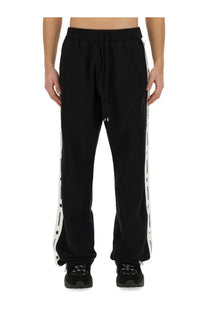 Dsquared2 men’s black jogging pants featuring white side stripes with repeated brand logo for casual wear