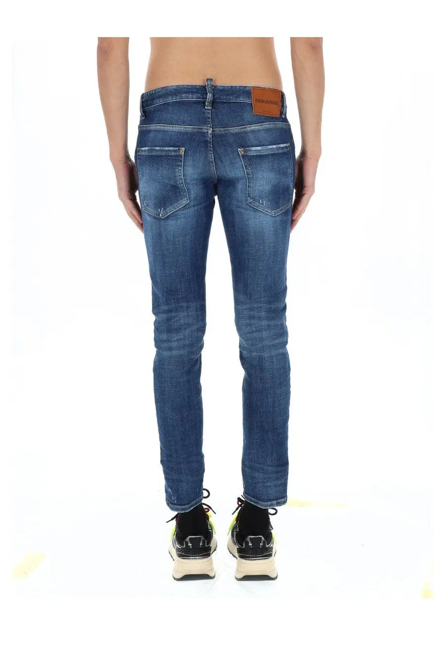 Back side of dsquared2 men’s skater jeans blue in slim fit faded wash denim with brown leather brand patch on waistband