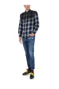 A man wearing dsquared2 men’s skater jeans blue in distressed denim paired with a dark blue and black plaid shirt
