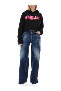 Black cropped hoodie with bold pink drillin lettering and small dsquared2 logo on waistband paired with blue traveller jeans