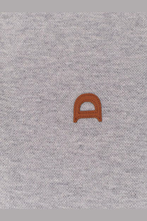 A tan leather d patch with stitched edges sewn onto heather gray fabric of dunst men’s polo shirt gray