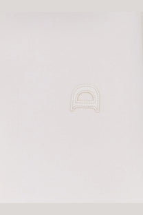 White leather letter d charm with stitched edges on dunst men’s unisex polo shirt white