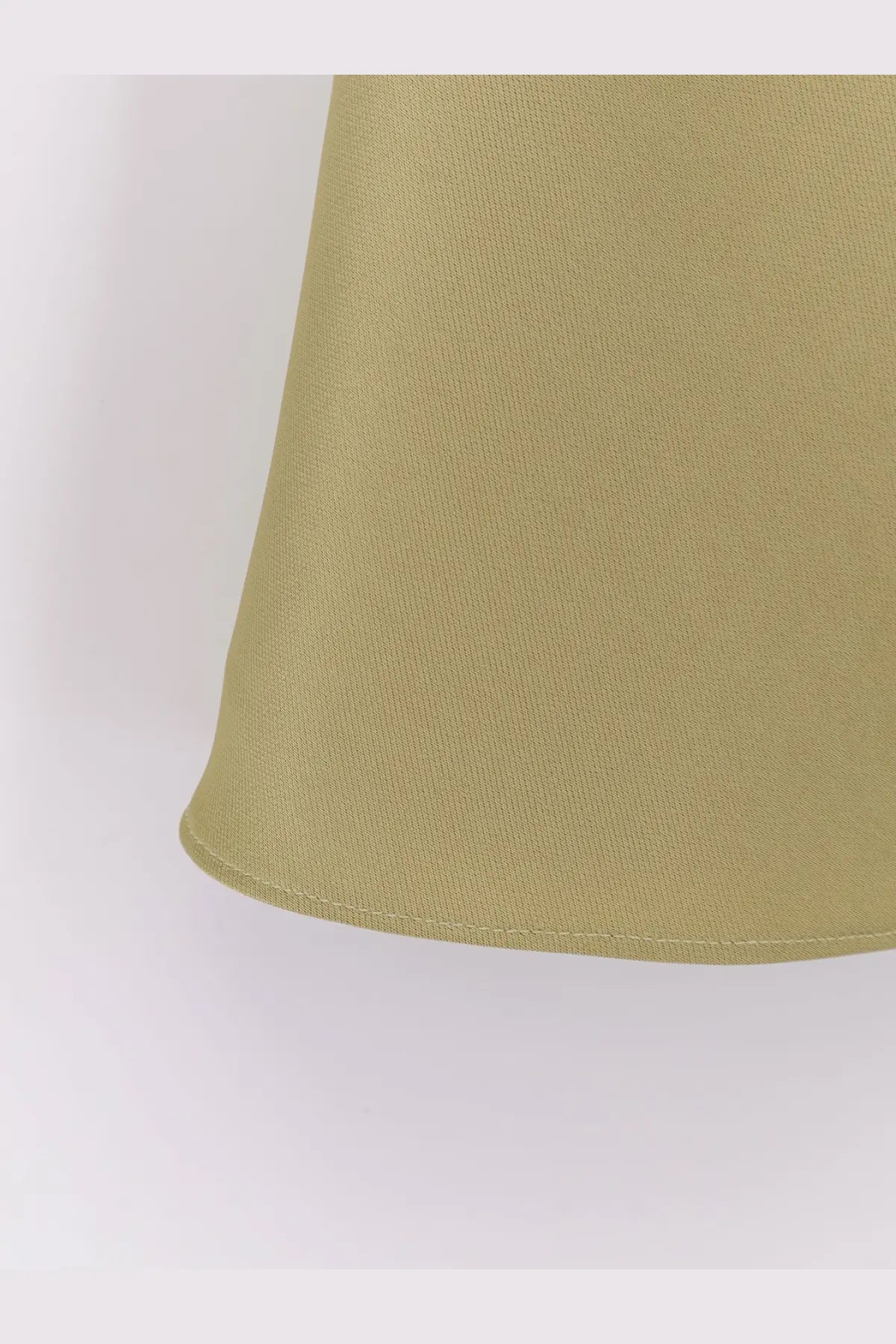 A close-up of dunst women’s olive-green satin skirt with subtle vertical pleats and a neatly stitched hem