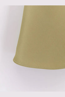 A close-up of dunst women’s olive-green satin skirt with subtle vertical pleats and a neatly stitched hem