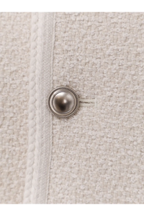A silver-toned rope border button on the textured off-white bouclé tweed fabric of a DunSt women’s unisex blazer