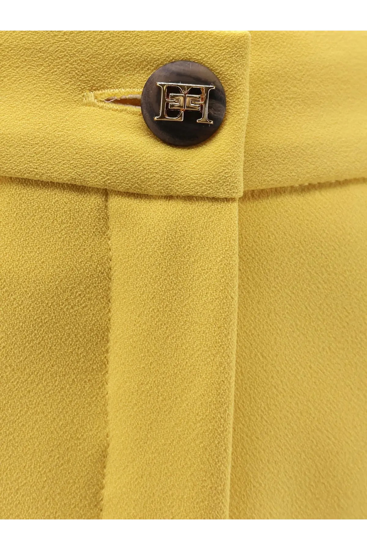 A dark brown circular button with metallic eh logo on mustard yellow fabric of elisabetta franchi womens events shorts