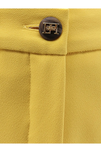 A dark brown circular button with metallic eh logo on mustard yellow fabric of elisabetta franchi womens events shorts