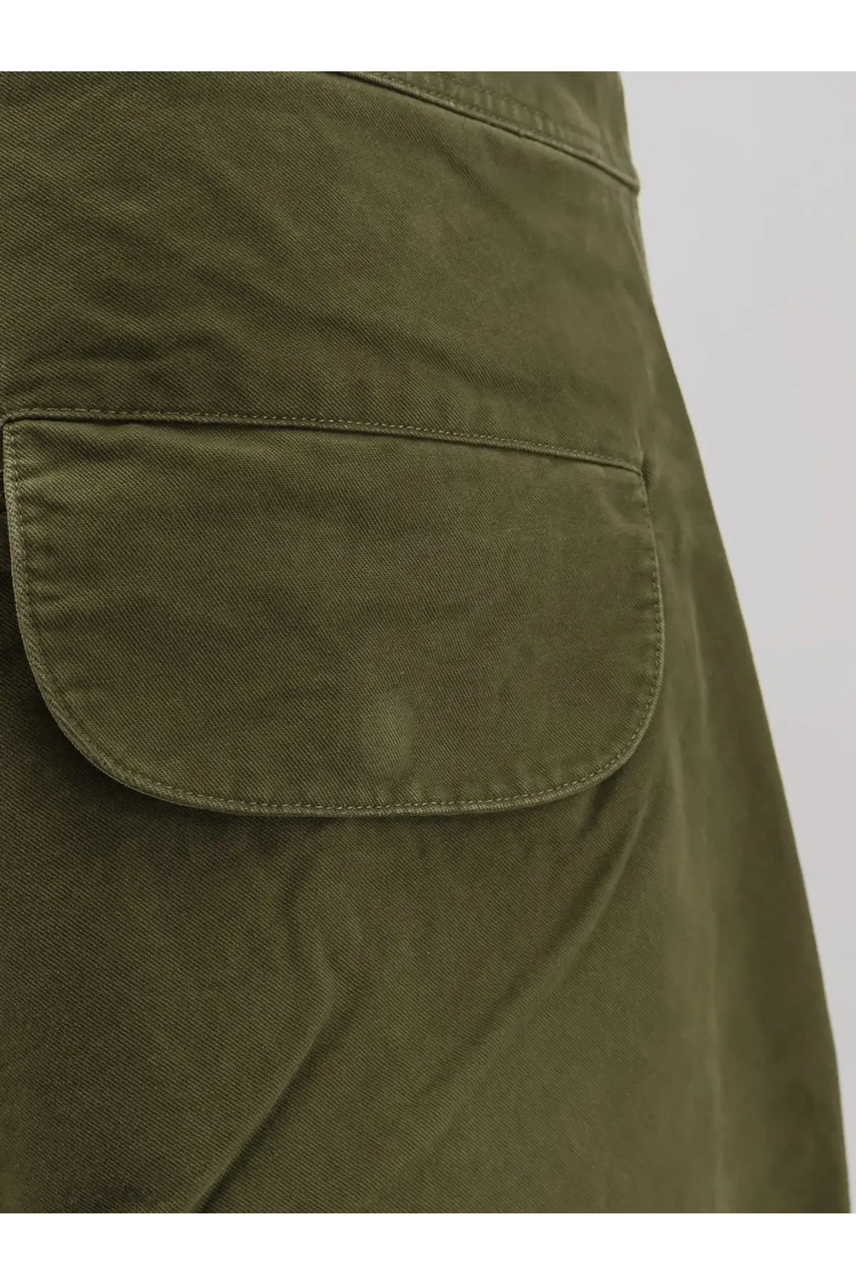 Olive green cotton pocket detail on entire studios unisex barren cargo trousers pine color front side view