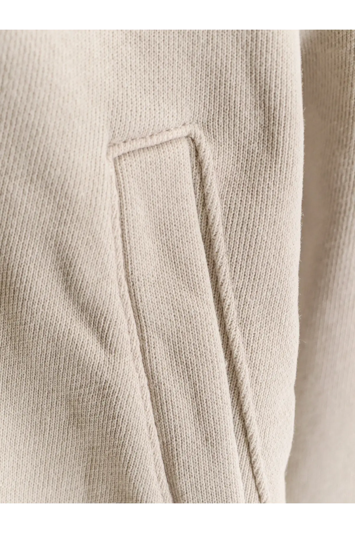Beige ribbed knit fabric with stitched pocket detail on entire studios unisex eternal zip cotton sweatshirt white