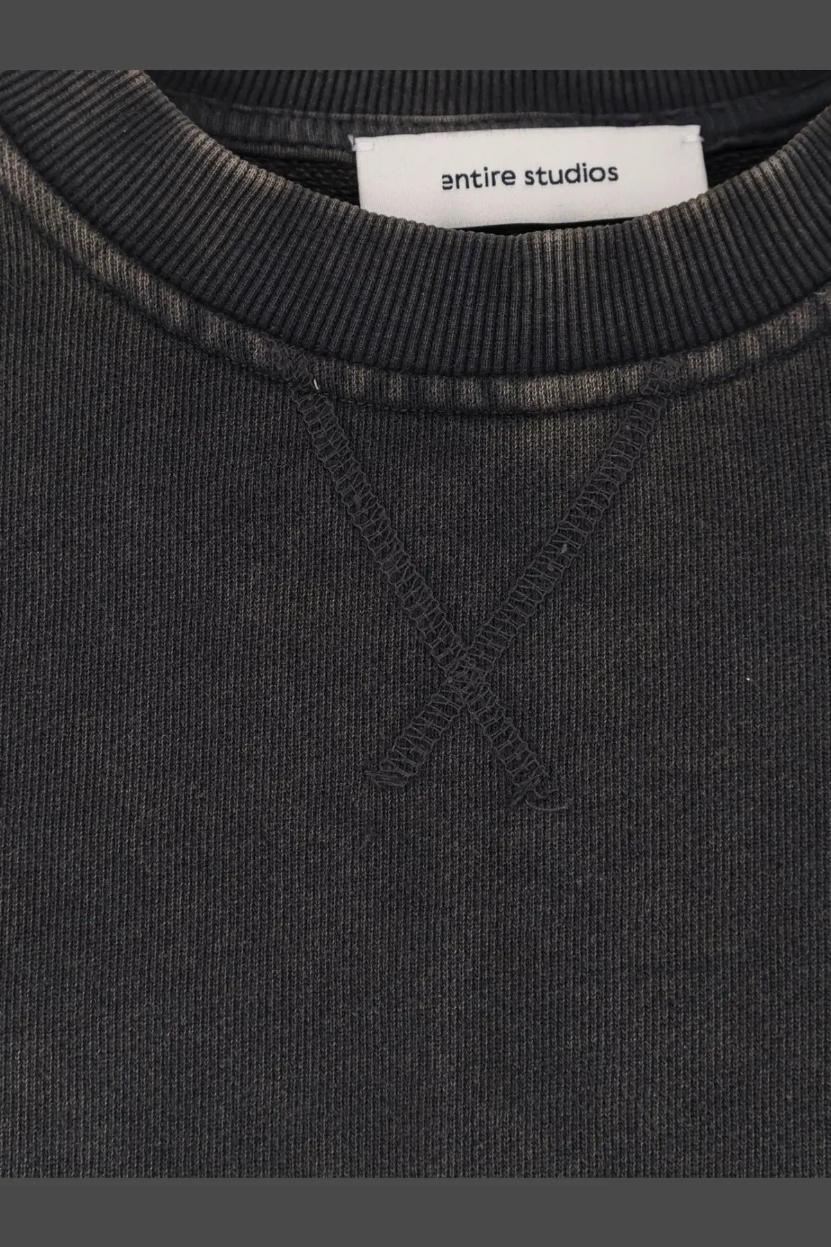 Black ribbed crewneck sweatshirt with subtle faded texture and Entire Studios brand label in cotton blend