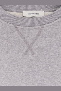 A heather gray unisex pod crew cotton sweatshirt with ribbed collar and entire studios brand label