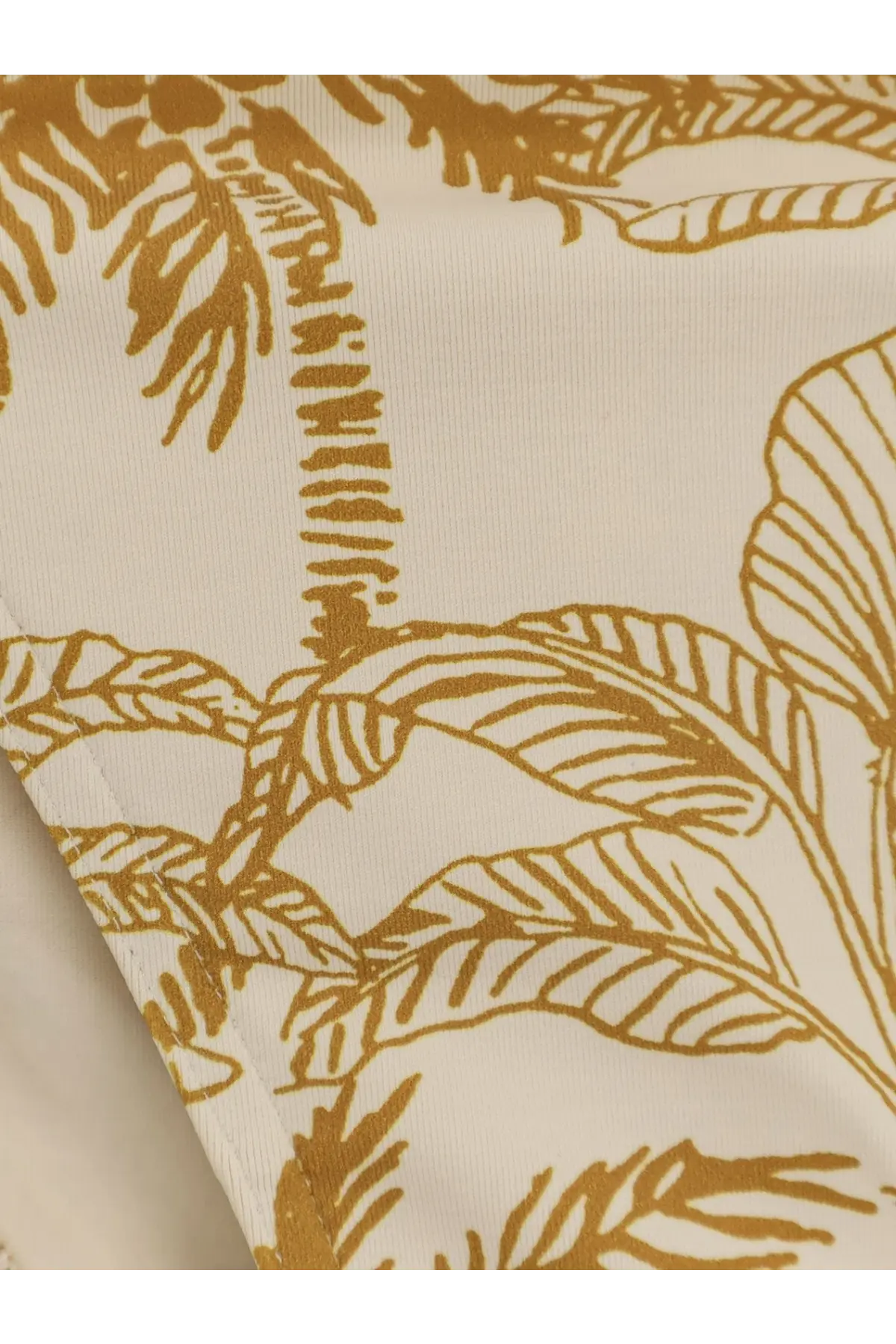 Cream-colored nylon bikini bottom with gold tropical palm tree and leaf pattern from eres womens swimwear