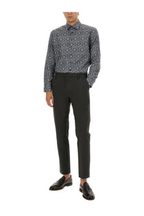 A man wearing etro men’s multicolor cotton shirt with dark gray and navy geometric patterns and black tailored trousers