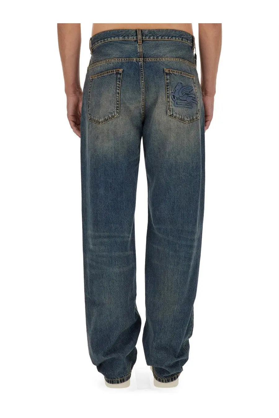 Back side of etro men’s blue denim jeans with faded wash and embroidered logo on the back right pocket