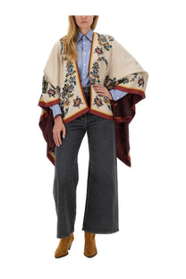 Eto women’s baggy jacquard jeans grey paired with a beige embroidered cape with blue green and maroon floral accents