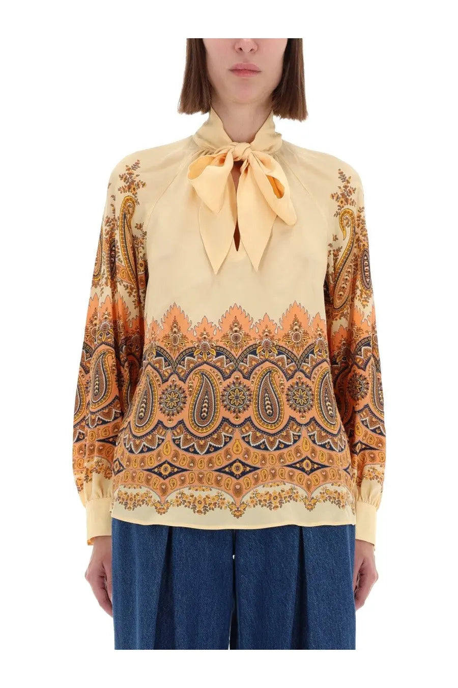 Etro women’s cream-colored blouse with intricate orange and brown paisley pattern and matching fabric bow at neckline