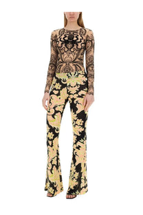 A woman wearing etro women’s multicolor printed jersey flared pants with black and peach floral long sleeves