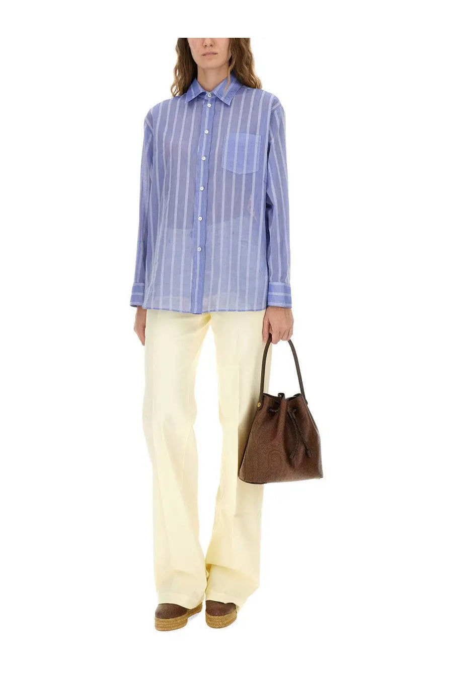 Brown leather bucket bag with drawstring closure paired with etro women’s striped blue cotton shirt