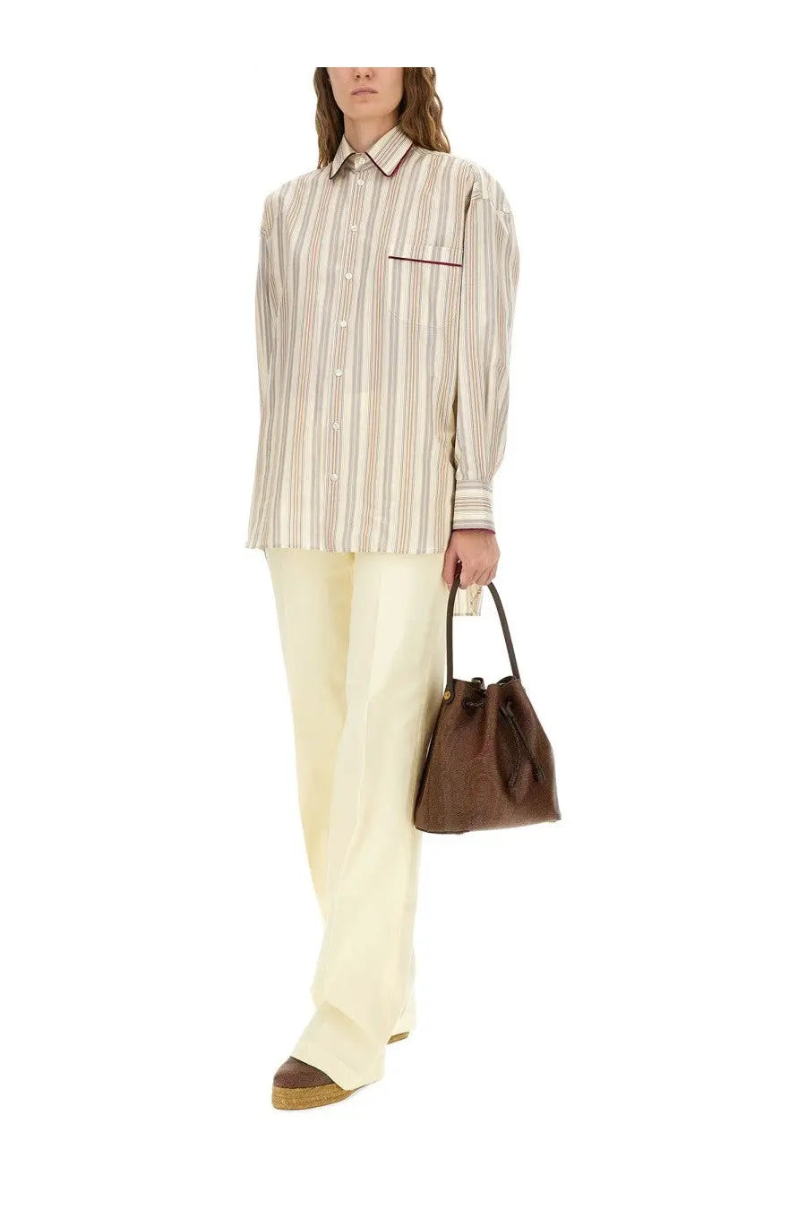 Brown leather bucket bag with drawstring closure shown alongside etro women’s multicolor striped cotton shirt
