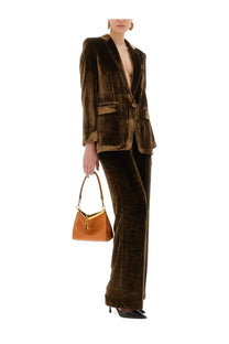 A structured caramel leather handbag with gold clasp and handle paired with etro women’s brown velvet jacket