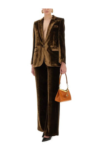 A rich burnt-orange leather handbag with gold-tone hardware and a structured triangular shape paired with etro women’s velvet pants brown