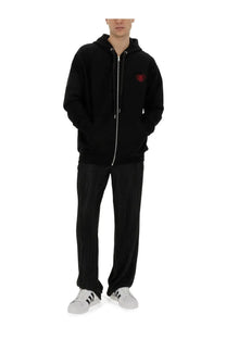 Black family first men’s pleated pants shown with a black zip-up hoodie featuring a red embroidered heart and silver zipper trim