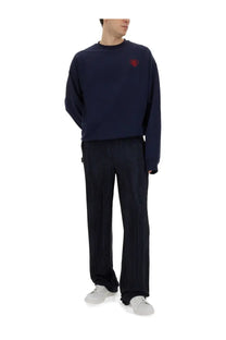 Navy blue oversized sweatshirt with red embroidered heart on left chest paired with family first men’s pleated blue pants