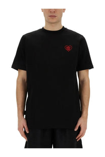 Family First men’s black short-sleeved t-shirt made of cotton with a small red embroidered heart logo on the left chest