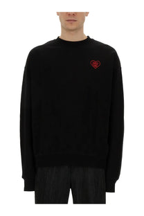 Black crewneck family first men’s sweatshirt with small red embroidered heart logo on the left chest