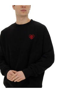 Family first men’s black long-sleeved crewneck sweatshirt with small red embroidered heart logo on left chest