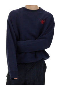 Navy blue crewneck sweatshirt with a red embroidered heart patch reading family first on the left chest