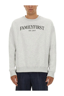 A heather gray crewneck sweatshirt for men with familyfirst est printed on the front in soft cotton blend fabric
