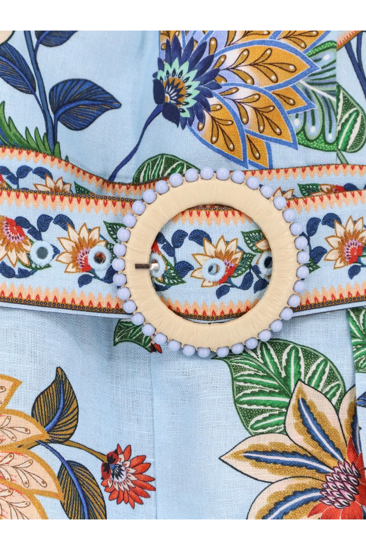 A light blue linen belt with floral print and a circular wooden buckle with small white beads for FARM Rio jumpsuit