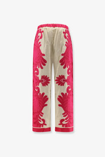 Cream-colored satin pants with bold pink floral embroidery and matching pink elastic waistband from farm rio