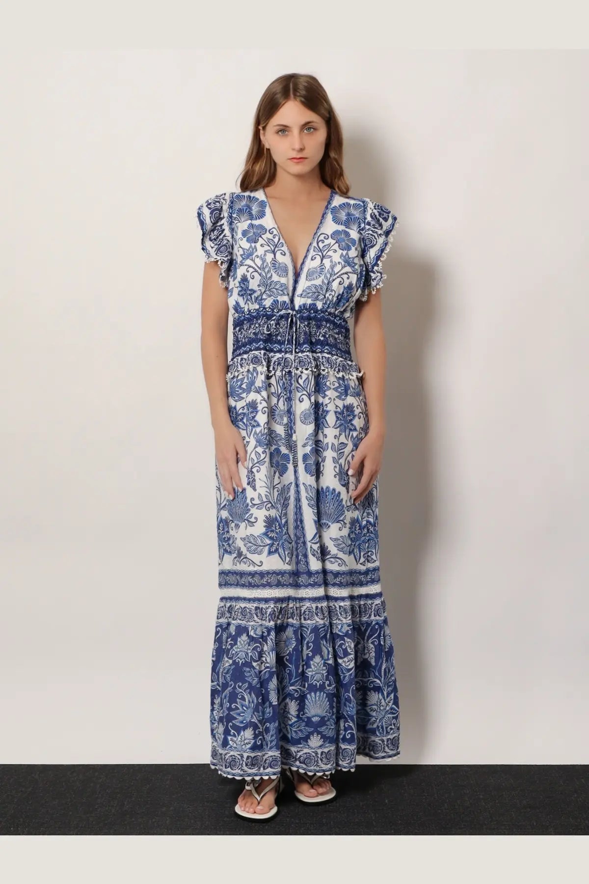 Farm Rio women’s shell garden cotton long dress in white features blue and white floral print with ruffled sleeves and tiered hem