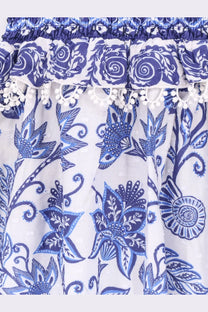 Farm Rio women’s shell garden cotton long dress white featuring intricate blue floral patterns and a ruffled hem with pom-poms