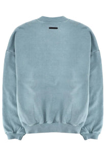 Fear of god essentials men’s light blue oversized sweatshirt with faded texture and black rectangular tag at neckline