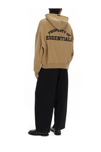 Beige fear of god essentials men’s hooded sweatshirt with black property of essentials lettering on the back