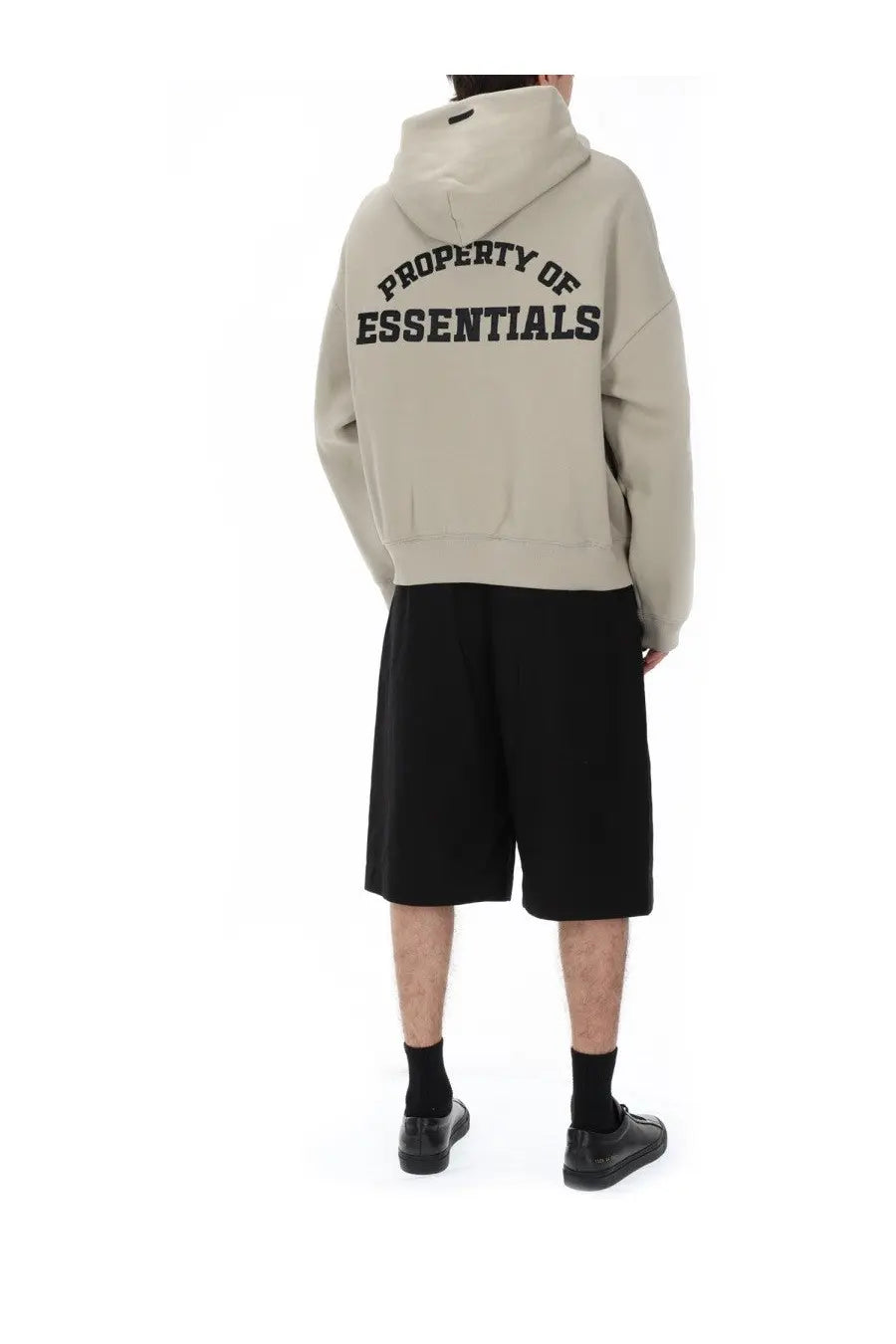 Back of fear of god essentials men’s beige hooded sweatshirt with black arched property of essentials lettering