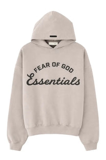 Beige fear of god essentials men’s felpa training hoodie with black arched lettering across the chest