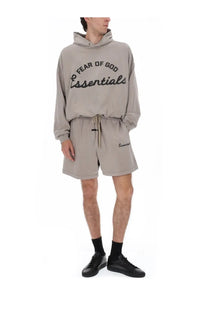 Beige Fear of God essentials men’s felpa training hoodie with black lettering and drawstring waistband in 90s grey style