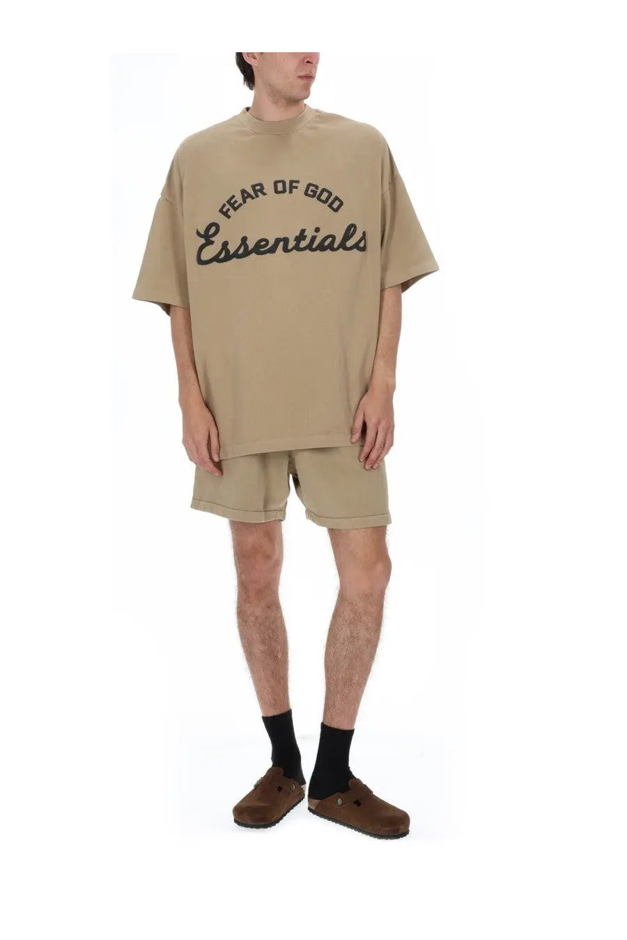 Beige oversized Fear of God Essentials men’s training t-shirt with black script logo printed across the chest