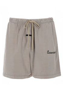 Beige fear of god essentials men’s athletic shorts with drawstring waistband and black embroidered essentials text