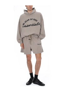 Beige fear of god essentials hoodie with black embroidered lettering and matching drawstring waistband for men