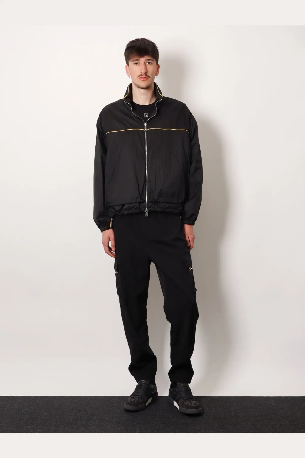 Black fila jacket with gold zipper and trim paired with fendi men’s black cargo nylon trousers