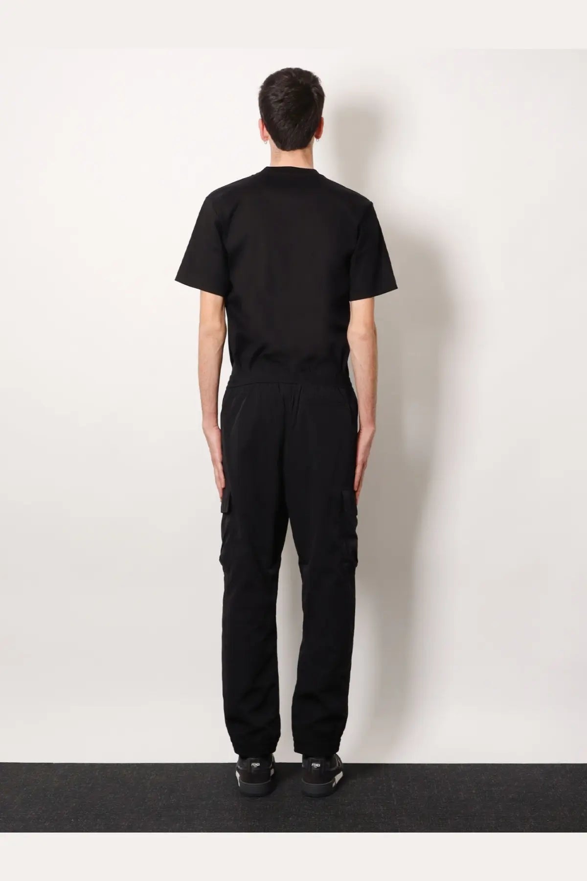 Black short-sleeved crew neck t-shirt with relaxed fit paired with fendi men’s black cargo nylon trousers